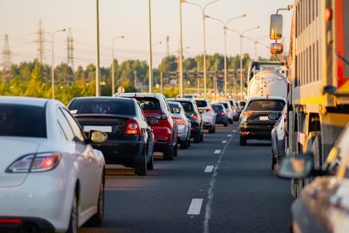 Heavy traffic on a multi-lane highway during rush hour in Houston, Texas, showing cars and trucks backed up under warm evening sunlight, symbolizing congestion and accident risk on the I-45 Gulf Freeway.