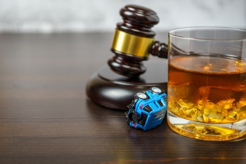 Houston drunk driving accident lawyer handling civil claims involving alcohol-related crashes symbolized by a gavel, whiskey glass, and toy vehicle.