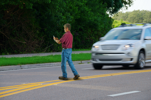A car drives on the road beside a white line, highlighting the importance of safety. Houston Pedestrian Accident Lawyer.