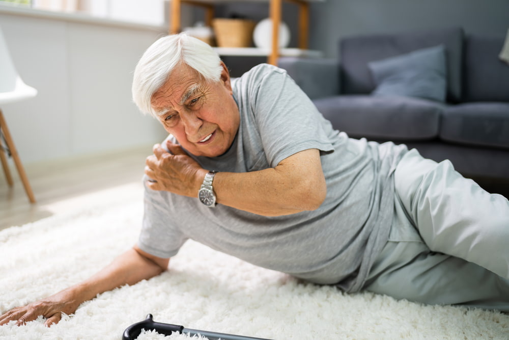 Older man lying on the floor in pain after a fall at home