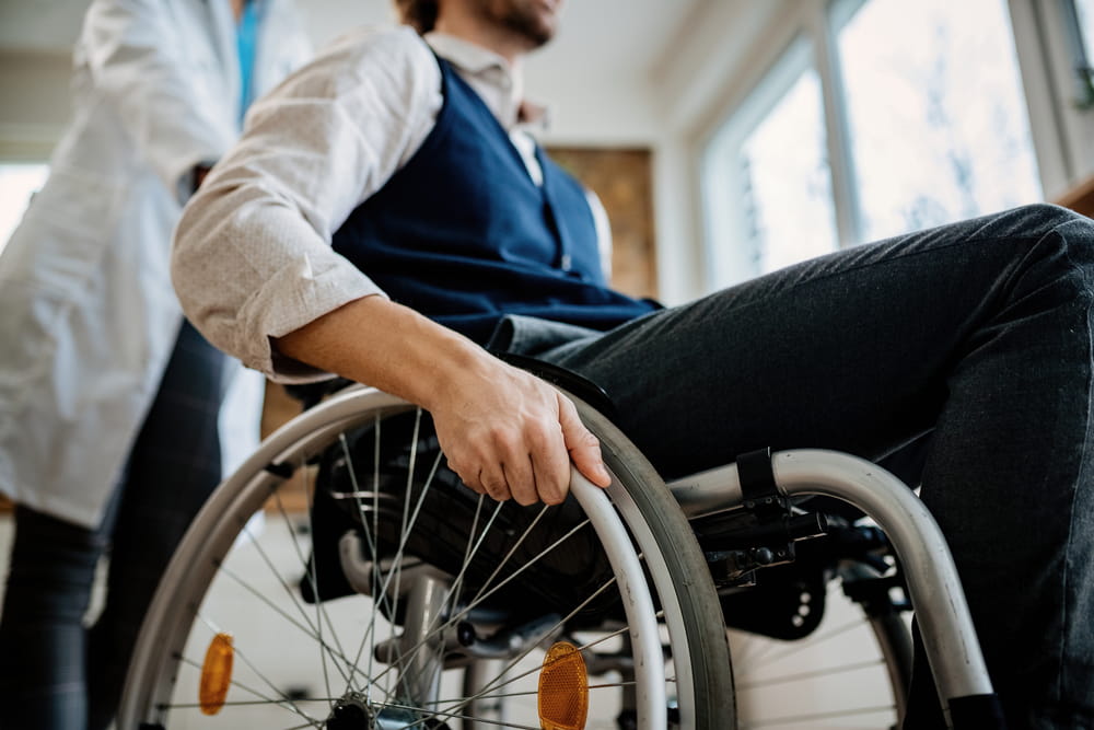 Person in a wheelchair assisted by a healthcare provider