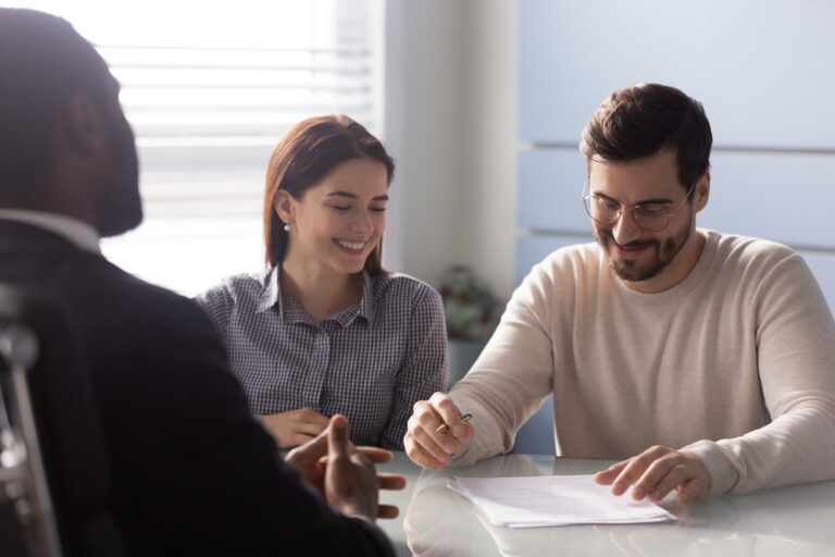 Couple reviewing and signing documents with a lawyer